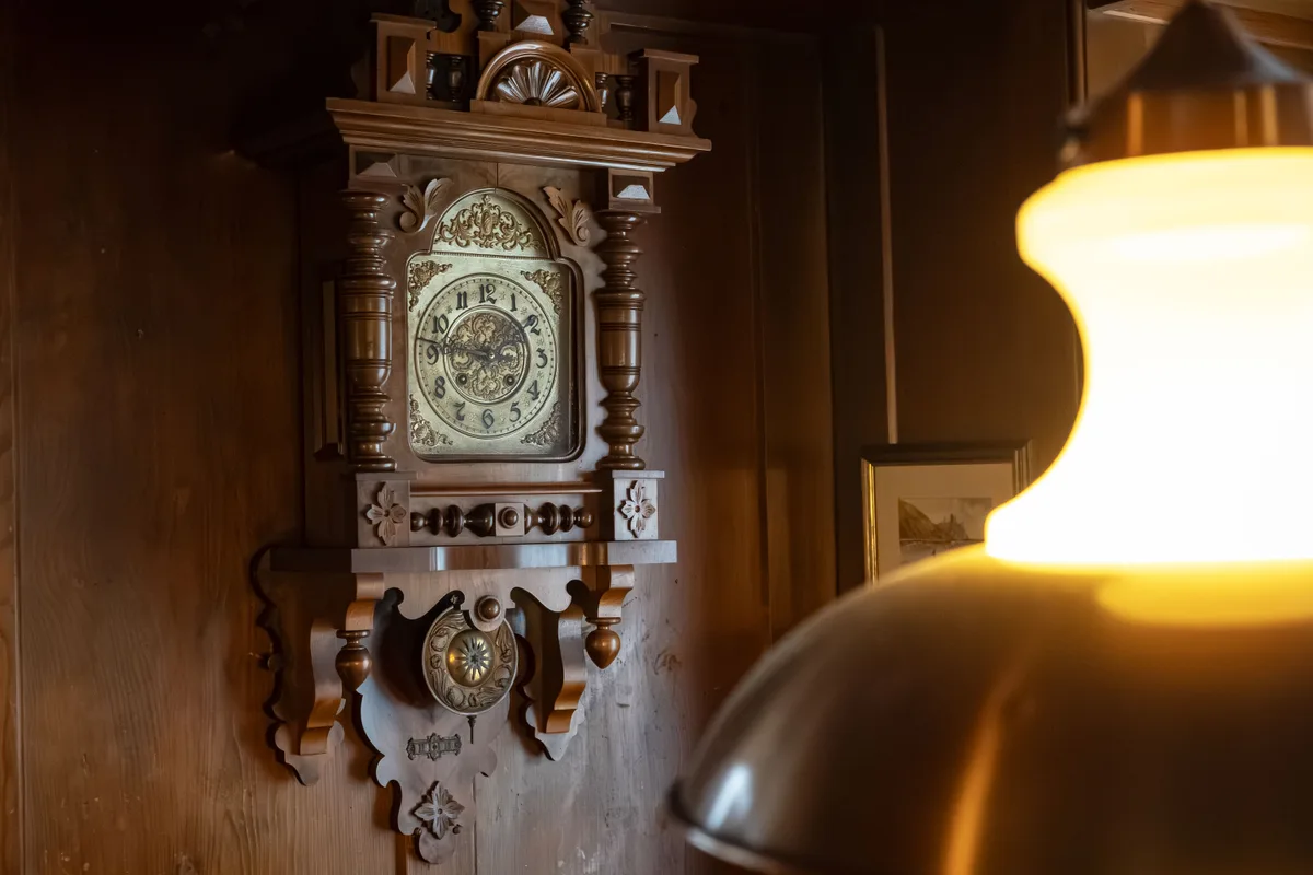 Wanduhr an einer dunklen Holzwand.